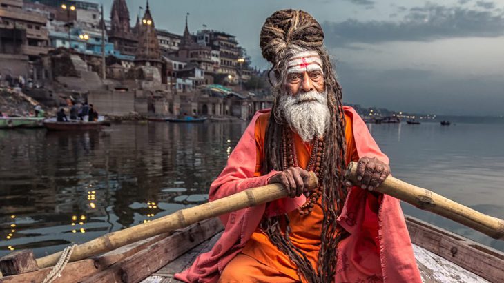 Holy man rowing on the Ganges