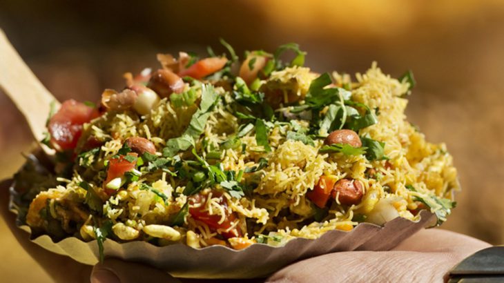 Man holding a plate of Bhelpuri in India