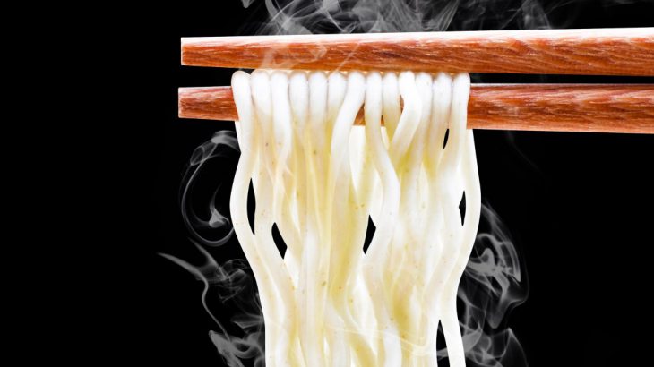 chopsticks with steaming noodles