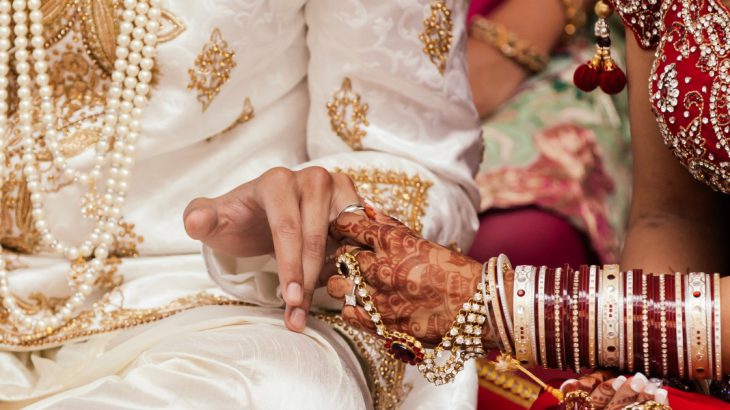 Bride and groom hold hands at a wedding