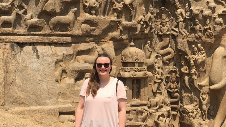 Chloe in front of a wall carving
