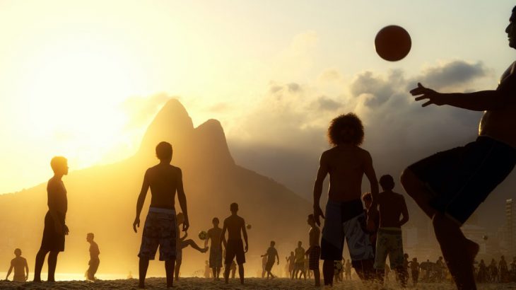 People playing football on the beach