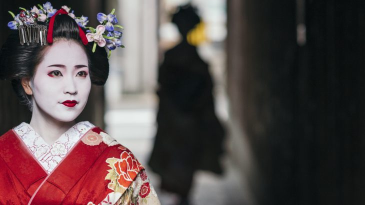 Geisha emerging from an old alleyway