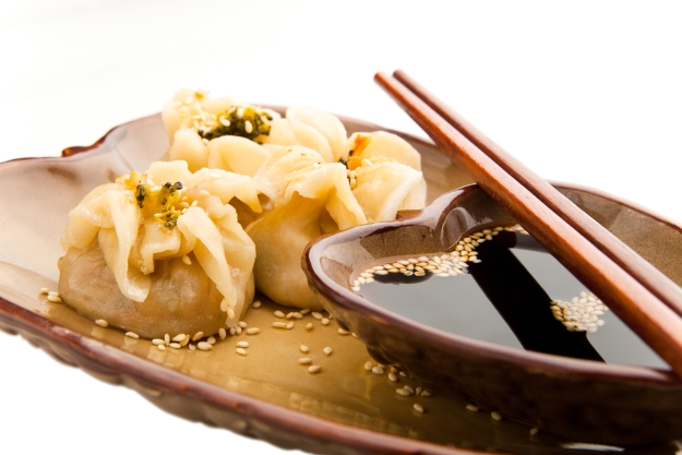A plate of dim sum and soy sauce.