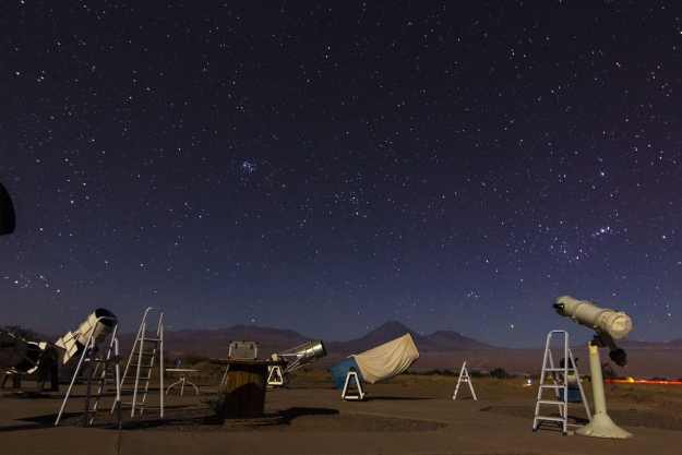 telescopes under a star filled sky