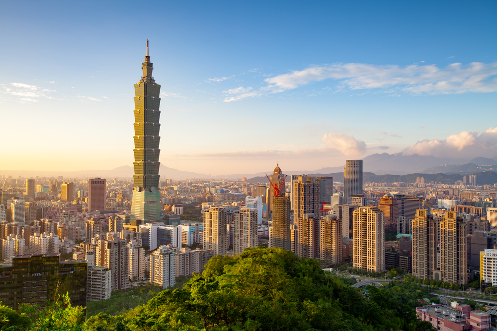 ChatGPT said: Aerial view of Taipei skyline at sunset featuring the iconic Taipei 101 and surrounding modern buildings.
